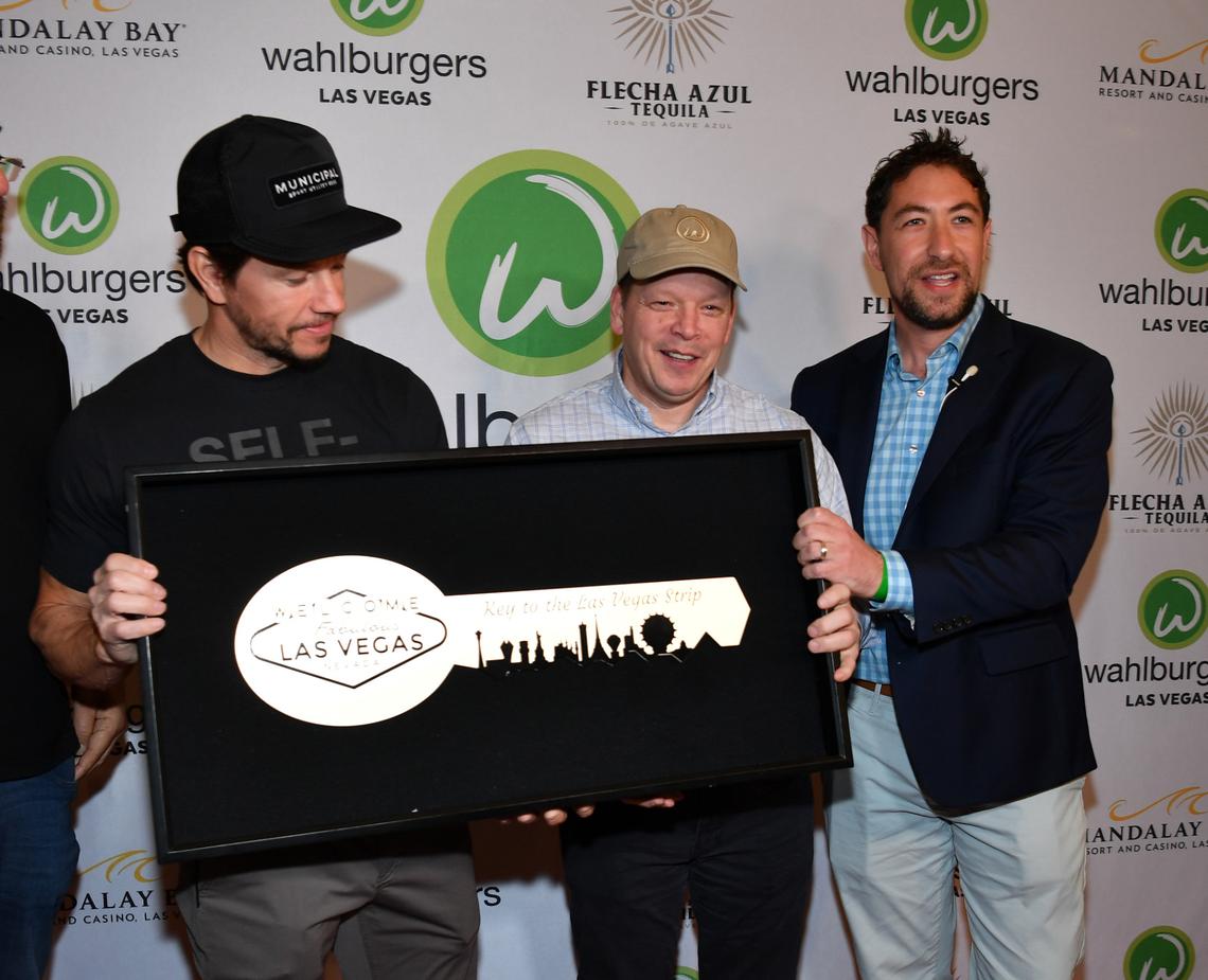 LAS VEGAS, NEVADA - MARCH 27: County Commissioner Michael Naft (R) presents Mark Wahlberg and Chef Paul Wahlberg with keys to the Las Vegas Strip at the grand opening of Whalburgers At Mandalay Bay Resort And Casino on March 27, 2023 in Las Vegas, Nevada. (Photo by Denise Truscello/Getty Images for Wahlburgers)
