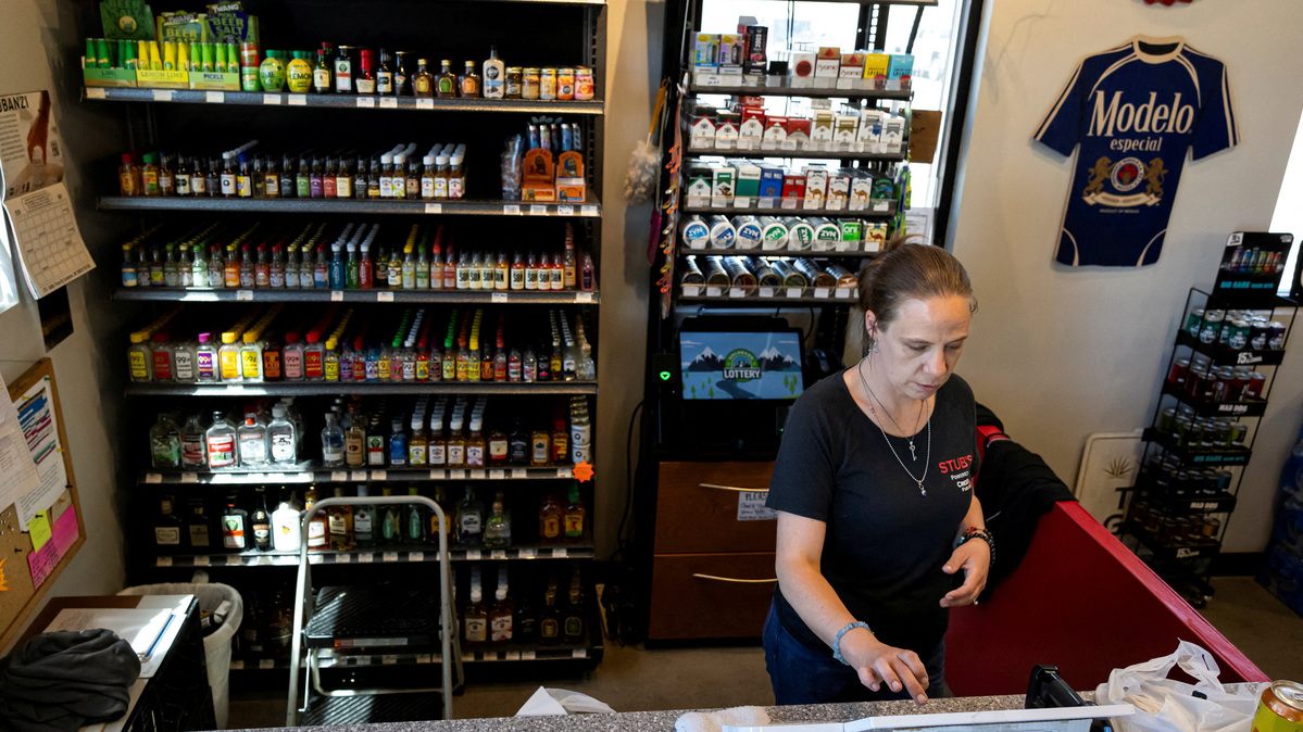 FILE PHOTO: A cashier checks out a customer at a liquor store in Wiggins, Colorado, U.S., May 11, 2026.  REUTERS/Kevin Mohatt/File photo