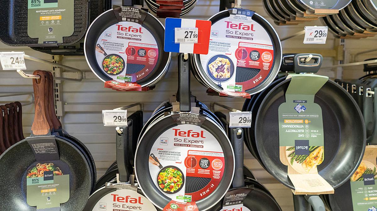 Display of nonstick frying pans of the Tefal brand hanging in the cookware aisle inside the Auchan hypermarket in Caluire et Cuire in France on December 4 2025. The main labels TEFAL So Expert and the price tags are clearly visible on the front packaging. (Photo by Antoine Boureau / Hans Lucas / AFP via Getty Images)
