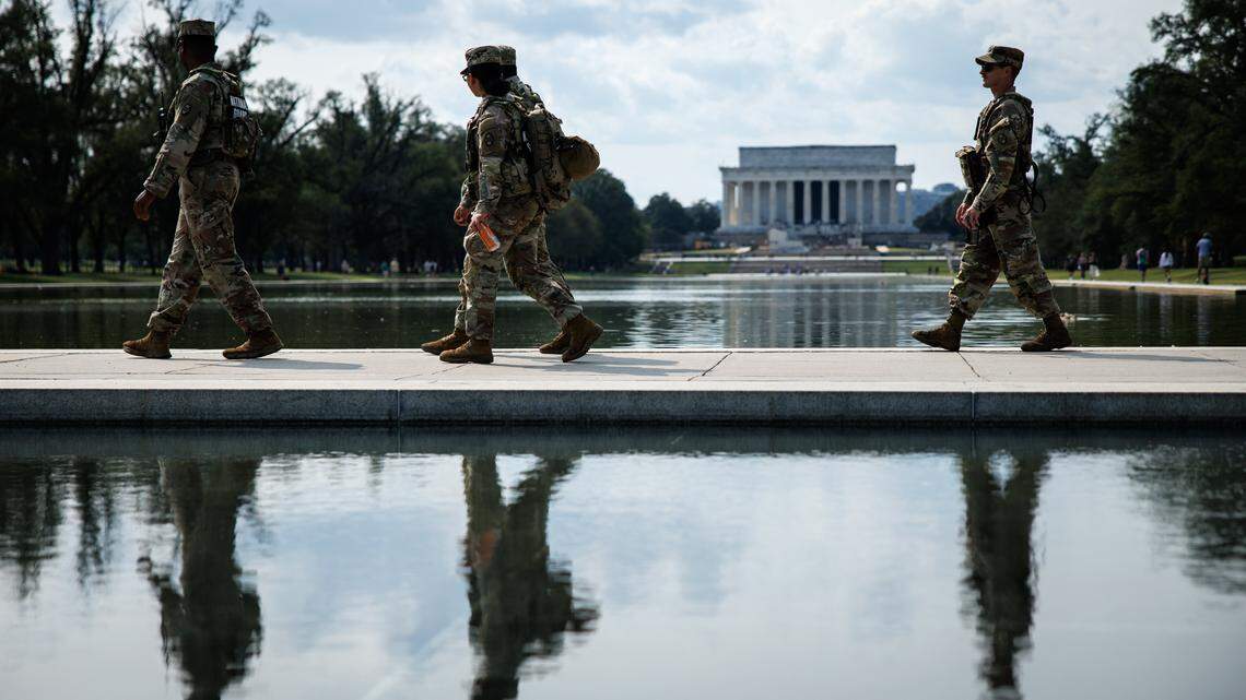 National Guard members walk along a path between the World War II Memorial and the Reflecting Pool during a patrol of the National Mall.