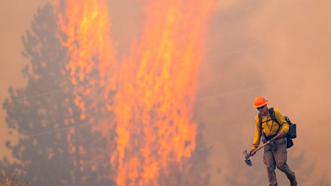 A wildland firefighter grimaces as he walks back to his crew in this 2021 file photo taken near Lenore, Idaho.