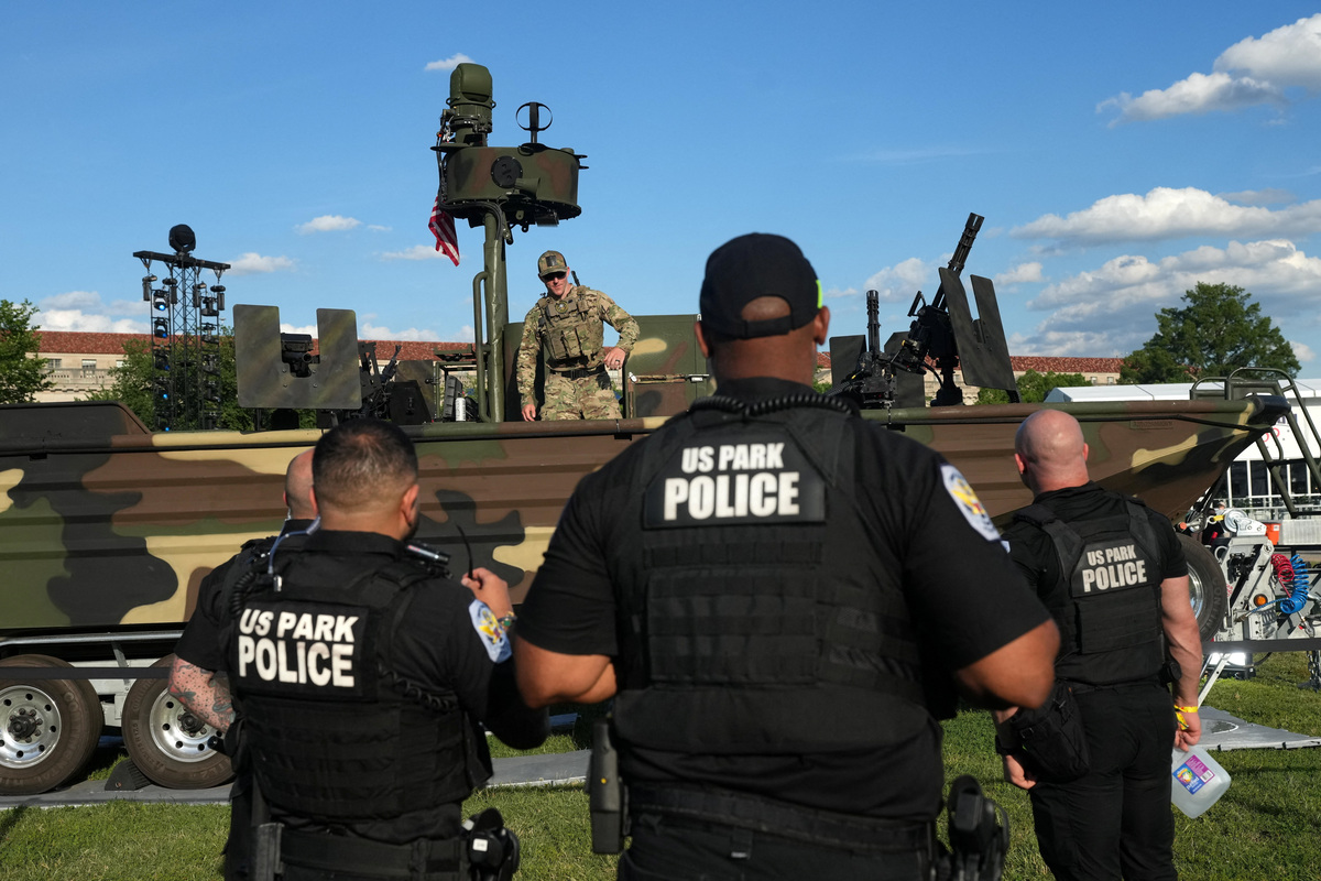 U.S. Park Police officers and a member of the military stand at the Fan Fest ahead of the ceremonial weigh-ins for fighters participating in UFC Freedom 250, at the Ellipse near the White House, in Washington, U.S., June 13, 2026. REUTERS/Nathan Howard