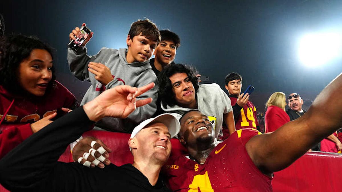  Nov 29, 2025; Los Angeles, California, USA; Southern California Trojans head coach Lincoln Riley (right) and defensive tackle Jahkeem Stewart (4) pose with fans after the game against the UCLA Bruins at United Airlines Field at Los Angeles Memorial Coliseum. Mandatory Credit: Kirby Lee-Imagn Images | Kirby Lee-Imagn Images 