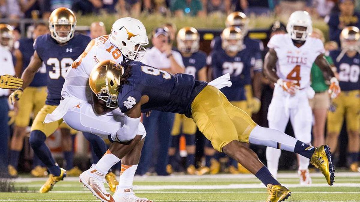  Sep 5, 2015; South Bend, IN, USA; Texas Longhorns quarterback Tyrone Swoopes (18) is tackled by Notre Dame Fighting Irish linebacker Jaylon Smith (9) in the second quarter at Notre Dame Stadium. | Matt Cashore-Imagn Images 