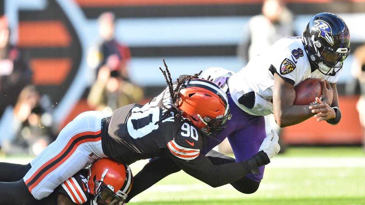 Cleveland Browns linebacker Jadeveon Clowney (90) tackles Baltimore Ravens quarterback Lamar Jackson (8) for no gain during the first half of an NFL football game, Sunday, Dec. 12, 2021, in Cleveland. (AP Photo/David Richard)