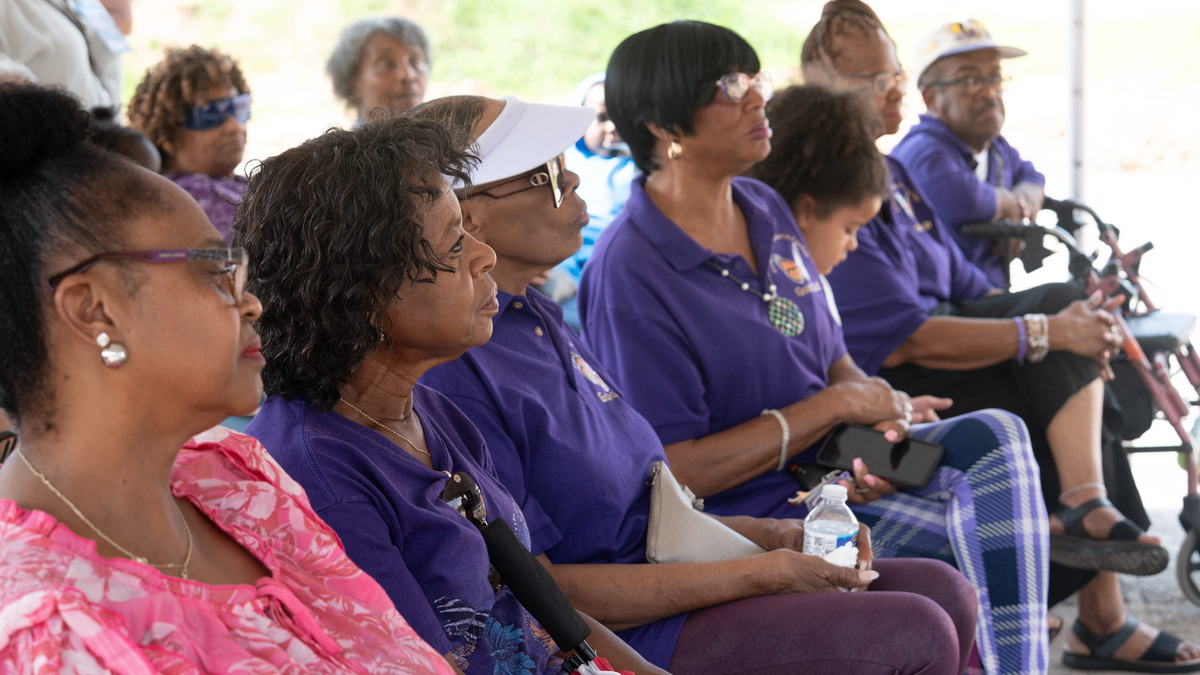 Residents listen during a renovation project groundbreaking event at the Fricker Resource Center in Pensacola on June 26, 2026.