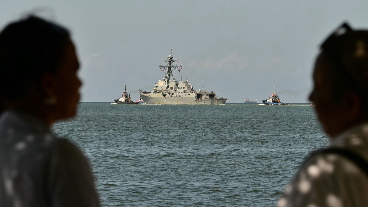 People watch the USS Gravely, a U.S. Navy warship, departing the Port of Spain on Oct. 30, 2025. The U.S. warship arrived in Trinidad and Tobago on Oct. 26, 2025, for joint exercises near the coast of Venezuela. (Martin Bernetti/AFP/Getty Images/TNS)