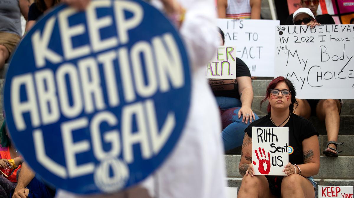 Protesters hold signs as Barbara DeVane, of the Tallahassee National Organization for Women, speaks outside the Florida Historic Capitol in Tallahassee, Fla., during a June 24, 2022, rally protesting the Supreme Court’s overturning of Roe v. Wade.