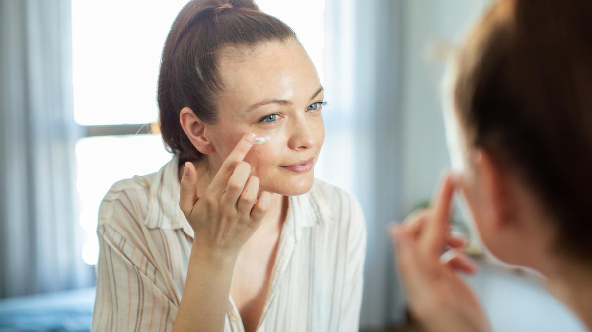 Close up of a young woman getting ready at home and putting on makeup
