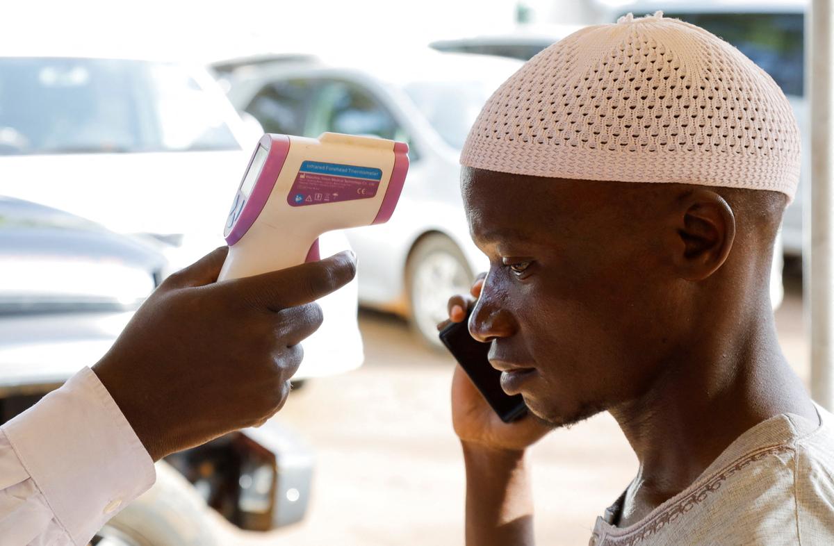 A medical officer checks the temperature of a man to screen against the spread of Ebola virus, as aid agencies intensify efforts to contain a new Ebola outbreak involving the Bundibugyo virus at the Platinum Medical Centre in Kampala, Uganda, May 26, 2026. REUTERS/Abubaker Lubowa