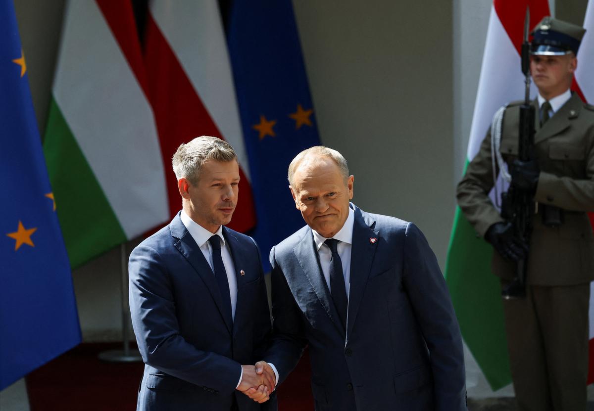 Poland's Prime Minister Donald Tusk shakes hands with Hungarian Prime Minister Peter Magyar during his first official visit to the country, in Warsaw, Poland, May 20, 2026. REUTERS/Kacper Pempel