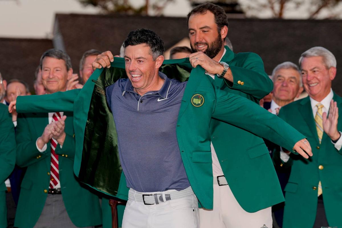  Scottie Scheffler places the champion's green jacket on Rory McIlroy after the final round of the Masters at Augusta National Golf Club on April 13, 2025. Kyle Terada-Imagn Images