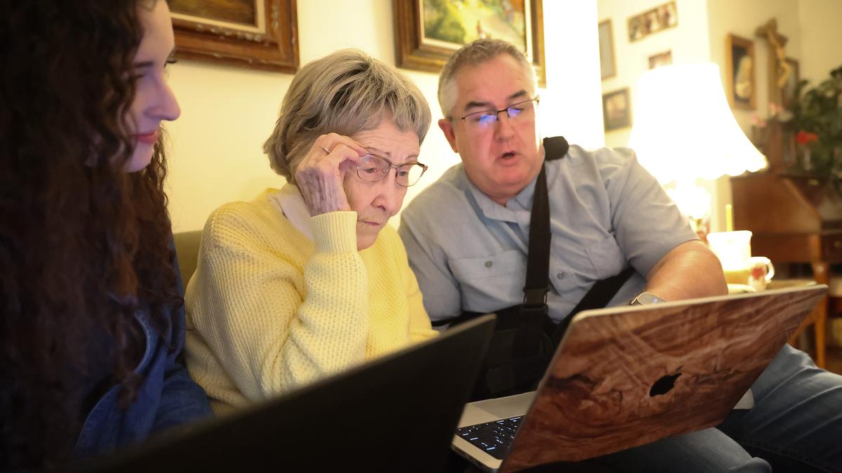 Nancy Lally (center) reads as her great-grand daughter Shannon Lally (left) and grandson Kelly Lally (right) search through records of the new unsealed records from the 1926 Ireland national census with her family in Roselle, Illinois, on Friday, April 17, 2026. The 1926 census was the first official records of Ireland following independence from the United Kingdom in 1922. (Talia Sprague/for the Chicago Tribune/TNS)