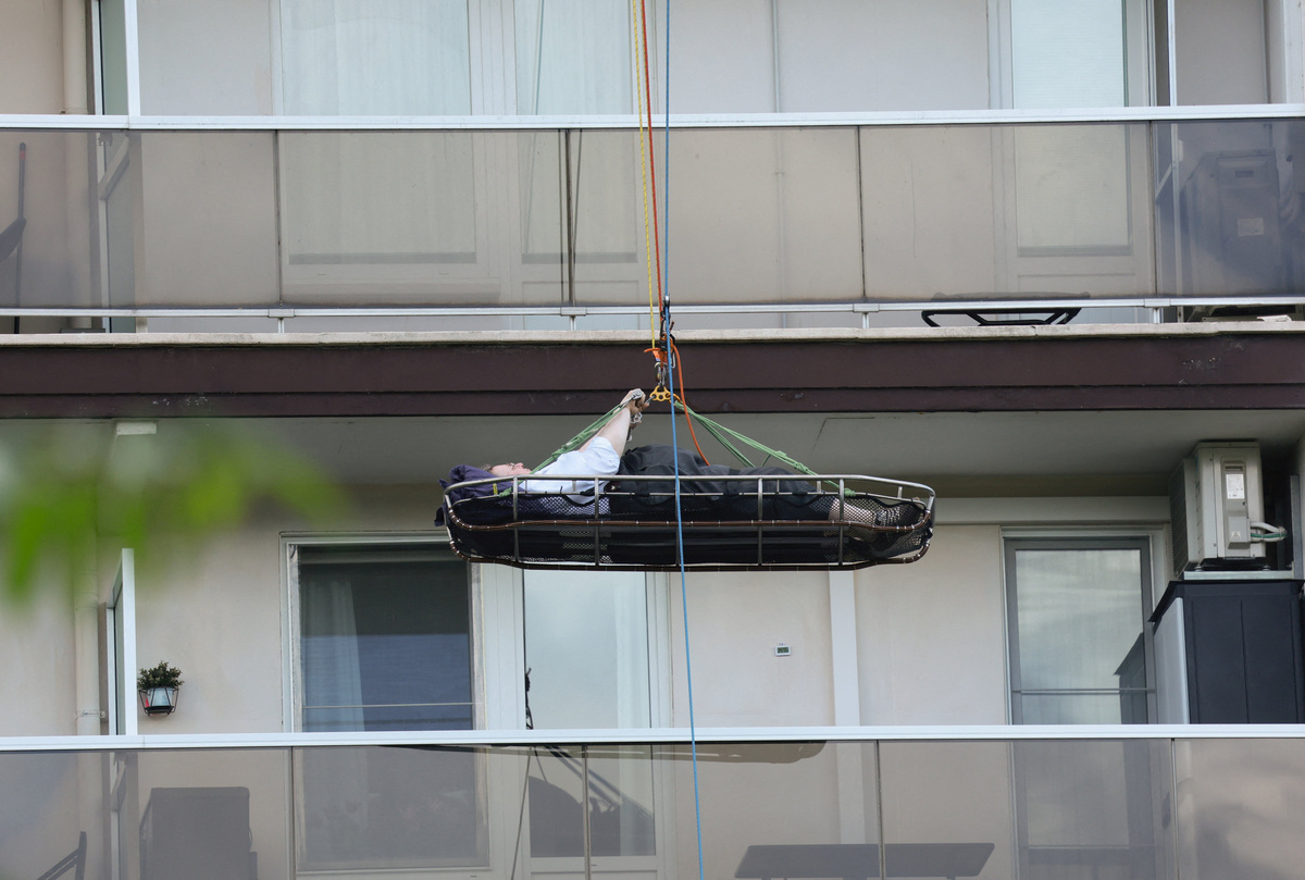 Rescuers evacuate a person at the site of a fire in an housing building in Antwerp, Belgium, July 1, 2026. REUTERS/Yves Herman