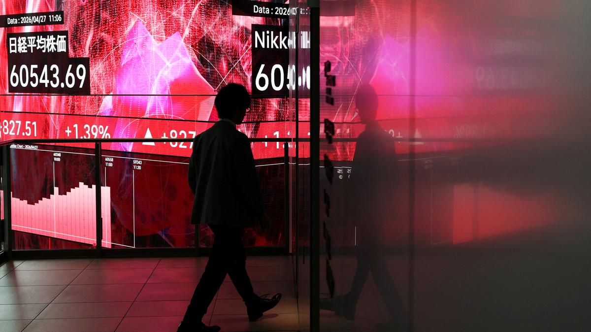 A man walks in front of an electronic screen displaying Japan's Nikkei share average inside a conference hall in Tokyo, Japan, April 27, 2026. REUTERS/Issei Kato