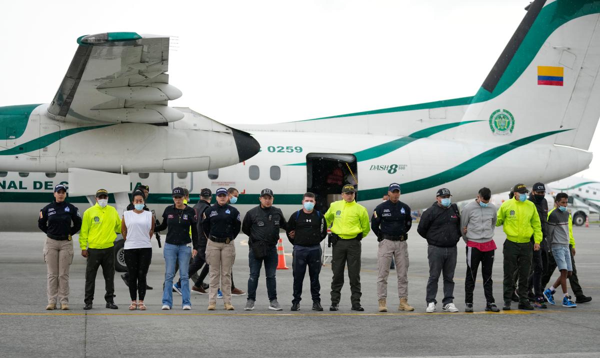La policía presenta a los medios de comunicación a cinco personas acusadas del asesinato del fiscal de Paraguay para casos de crimen organizado y narcotráfico, Marcelo Pecci, en la pista de un aeropuerto en Bogotá, Colombia, el miércoles 8 de junio de 2022. Pecci fue asesinado el 12 de mayo por hombres armados en una playa colombiana al sur de Cartagena mientras estaba de luna de miel.