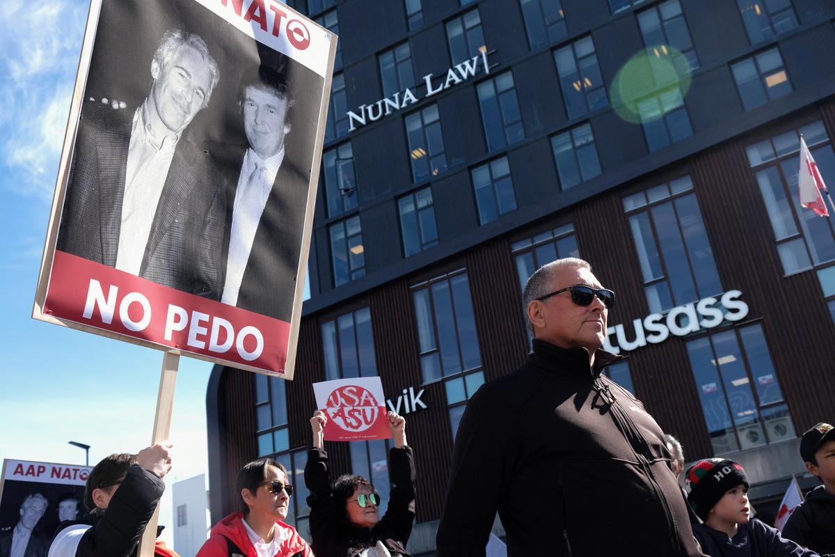 A protester holds a sign that reads 'Yes NATO, No Pedo' with a photo of U.S. President Donald Trump with late sex offender and financier Jeffrey Epstein, on the day of the opening of a new U.S. consulate in Nuuk, Greenland, May 21, 2026. REUTERS/Tim Barsoe