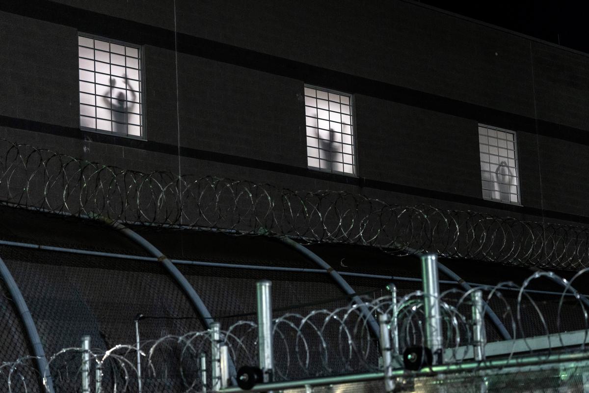 Inmates stands at windows at Delaney Hall, an immigration detention center in Newark, N.J., as demonstrators gather outside on Thursday night, May 28, 2026. For nearly a week, relatives of migrants at Delaney Hall have said that some detainees have been on a hunger strike at the facility. Federal officials have denied that a hunger strike is taking place. (Todd Heisler/The New York Times)