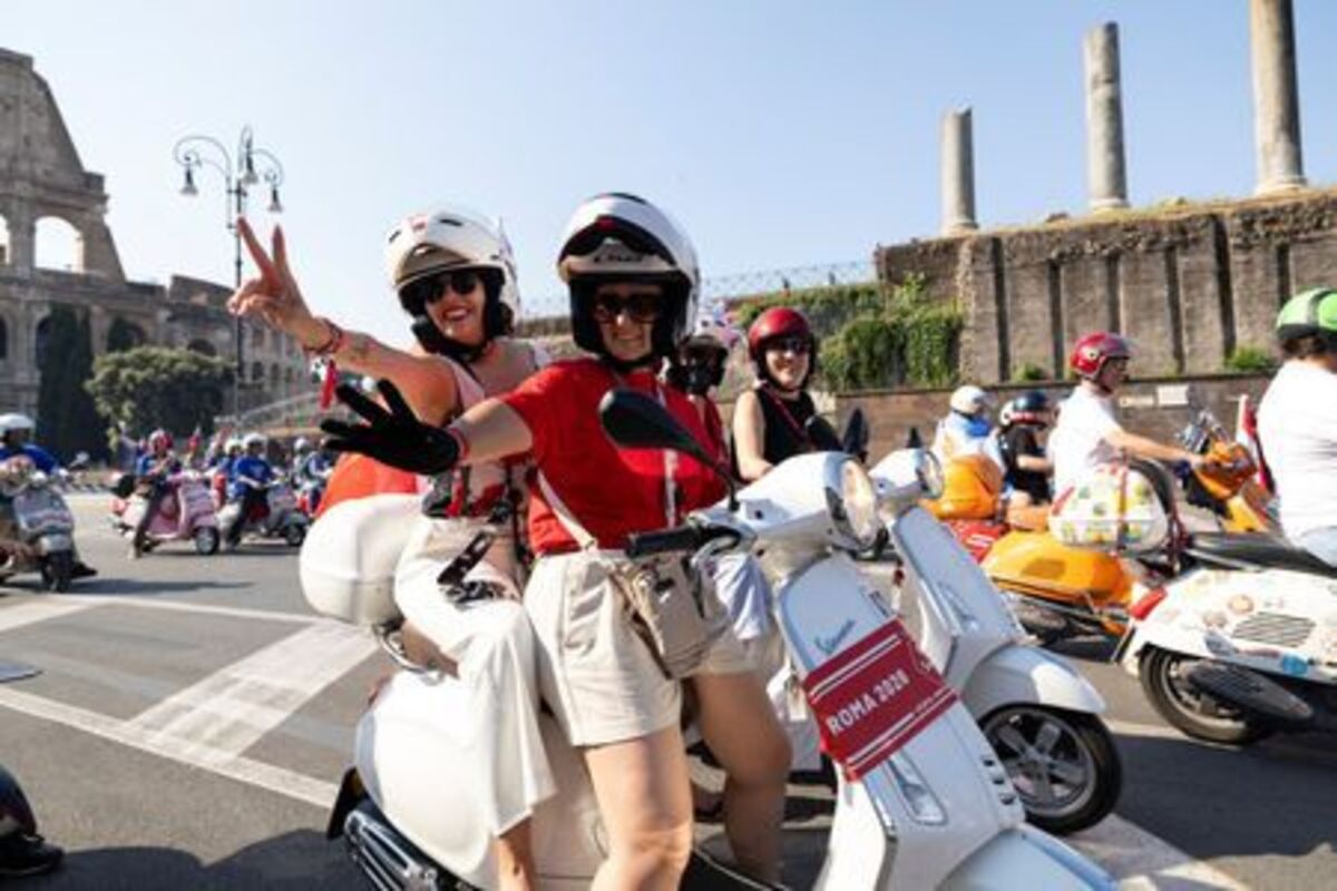 Vespa riders gesture as they drive near the Colosseum the last day of “Vespa Roma 2026 - 80 Years of an Icon”, a four-day global gathering marking the 80th anniversary of the iconic Italian scooter brand, in Rome, Italy, June 27, 2026. REUTERS/Remo Casilli