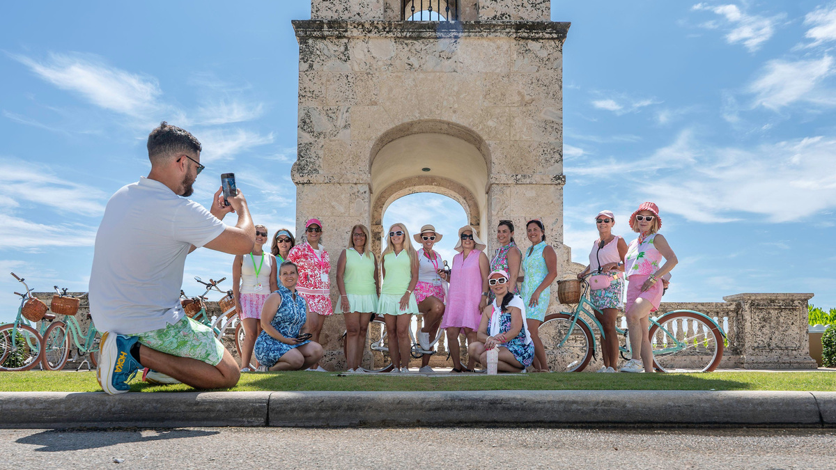 During a brief break in a guided 1-hour scenic bike tour through Palm Beach with Palm Beach EBike Rentals, a group of 2026 Pink Retreat participants pose for a photo at the Palm Beach Clock Tower on June 12.