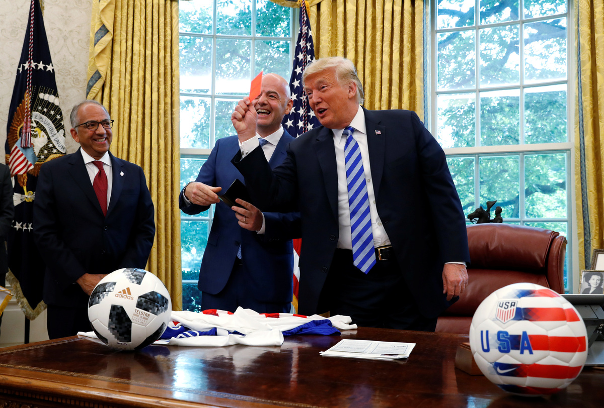 U.S. President Donald Trump holds up a red card as he meets with FIFA President Gianni Infantino in the Oval Office of the White House in Washington, U.S., August 28, 2018. REUTERS/Leah Millis