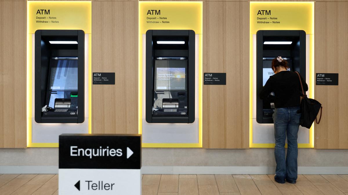 FILE PHOTO: A woman uses a Commonwealth Bank of Australia ATM at a branch in Sydney, Australia, August 19, 2025. REUTERS/Hollie Adams/File Photo