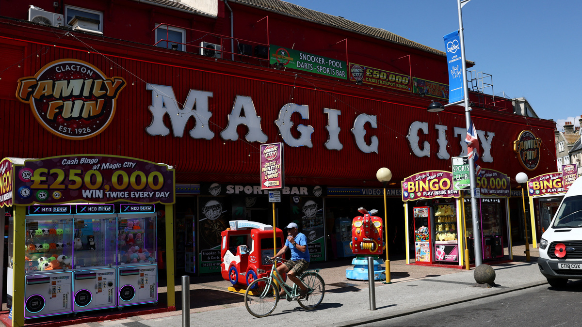 A man cycles past an amusement arcade in Clacton-on-Sea, after Leader of the Reform UK party Nigel Farage announced on Tuesday that he has resigned as an MP, triggering a by-election in the Clacton-on-Sea parliamentary seat, where he intends to stand for re-election, in Britain, July 8, 2026. REUTERS/Jack Taylor