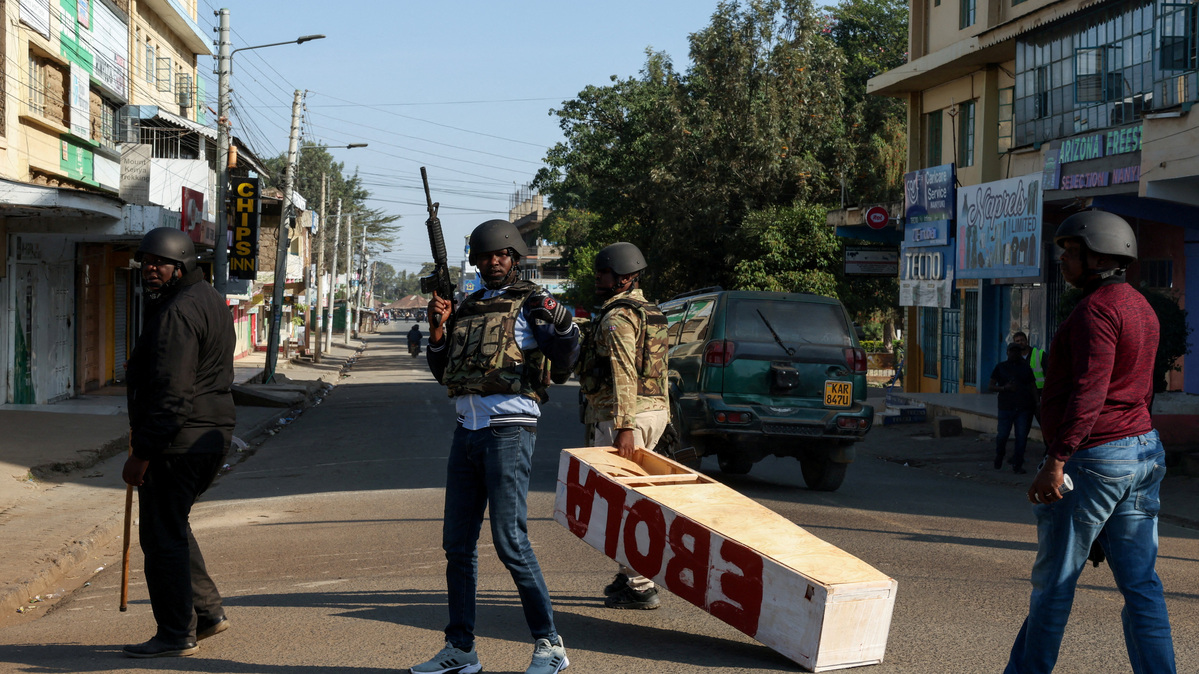 A police officer carries a mock coffin used as a prop by demonstrators, during a protest against a U.S.-backed Ebola quarantine plan to establish a 50-bed facility at a Kenyan air force base intended to host Americans exposed to Ebola, in Nanyuki town, Laikipia County, Kenya, June 9, 2026. REUTERS/Monicah Mwangi