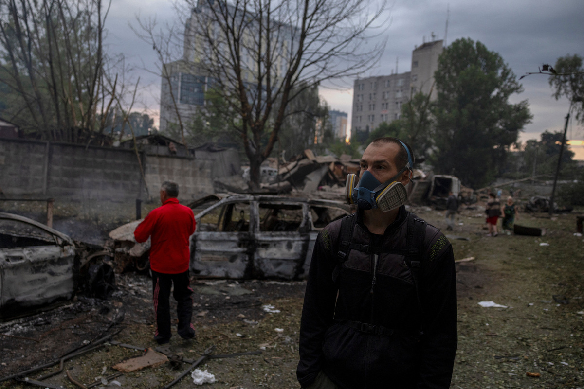 People survey the damage the site of an impact that set several cars ablaze during Russian missile and drone strikes, amid Russia's attack on Ukraine, in Kyiv, Ukraine July 6, 2026. REUTERS/Thomas Peter