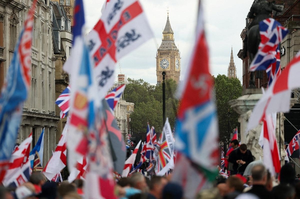 The Elizabeth Tower, commonly known as Big Ben, stands in the background as protesters hold flags during a "Unite the Kingdom" rally organised by British anti-immigration activist Stephen Yaxley-Lennon, also known as Tommy Robinson, in London, Britain, May 16, 2026. REUTERS/Hannah McKay