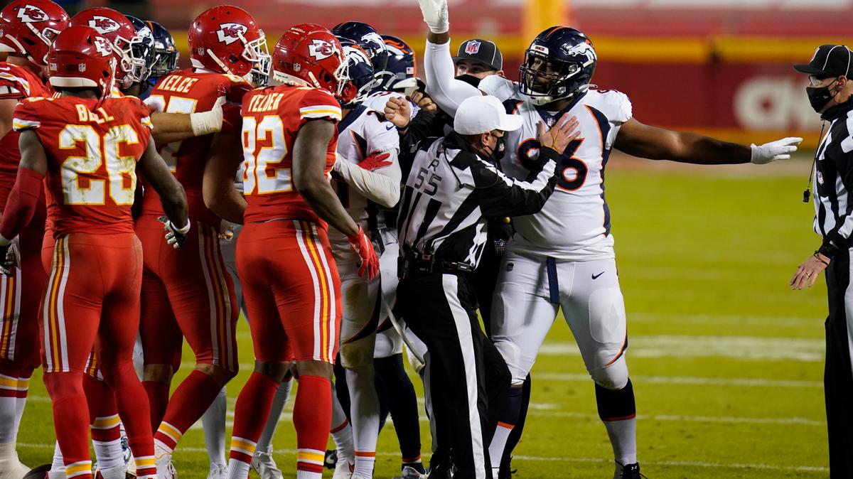 Referee Alex Kemp (55) holds Denver Broncos defensive end Shelby Harris (96) back from Kansas City Chiefs players in the first half of an NFL football game in Kansas City, Mo., Sunday, Dec. 6, 2020.