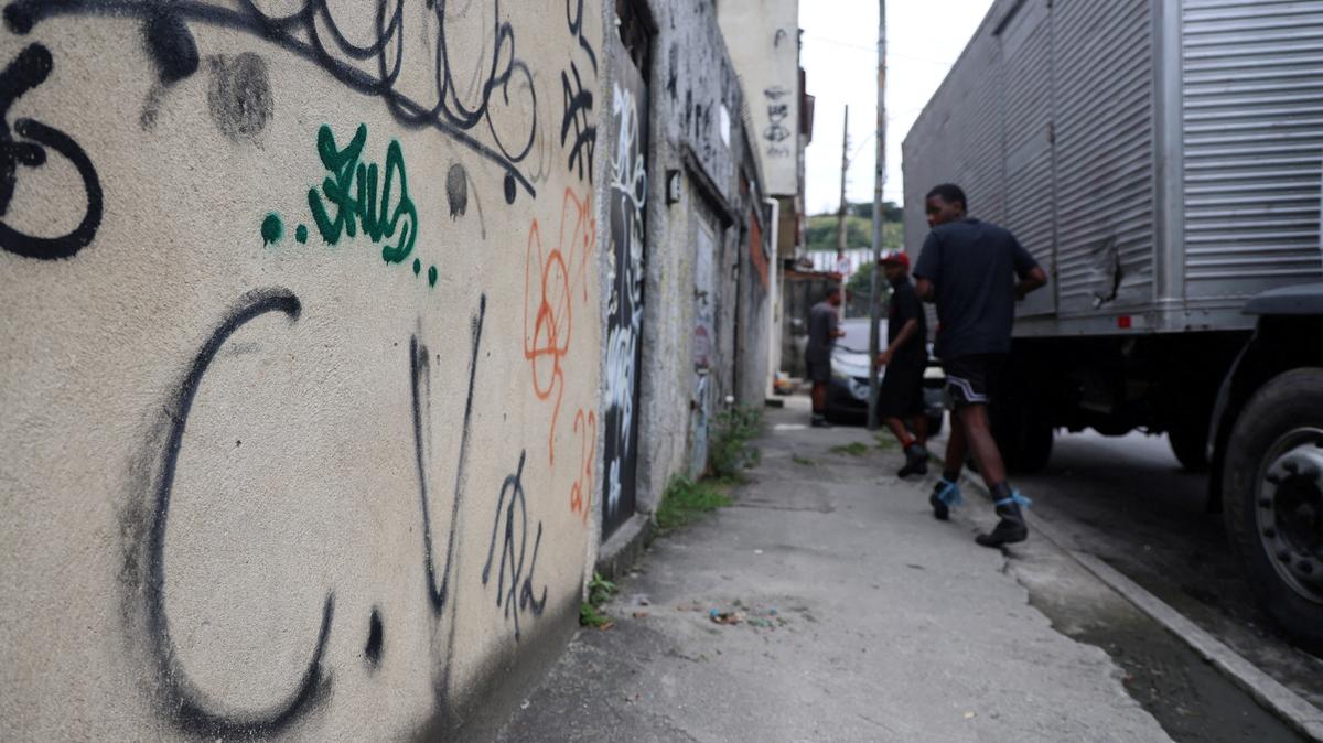 People walk past graffiti reading "C.V", referring to a Brazilian gang Comando Vermelho, in Penha neighborhood in Rio de Janeiro, Brazil May 29, 2026. REUTERS/Aline Massuca