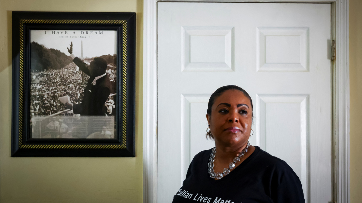 Farah Larrieux, a Temporary Protected Status (TPS) holder, poses for a portrait next to a Martin Luther King Jr. poster during an interview with Reuters, in Miami, Florida, U.S., June 28, 2026. REUTERS/Marco Bello