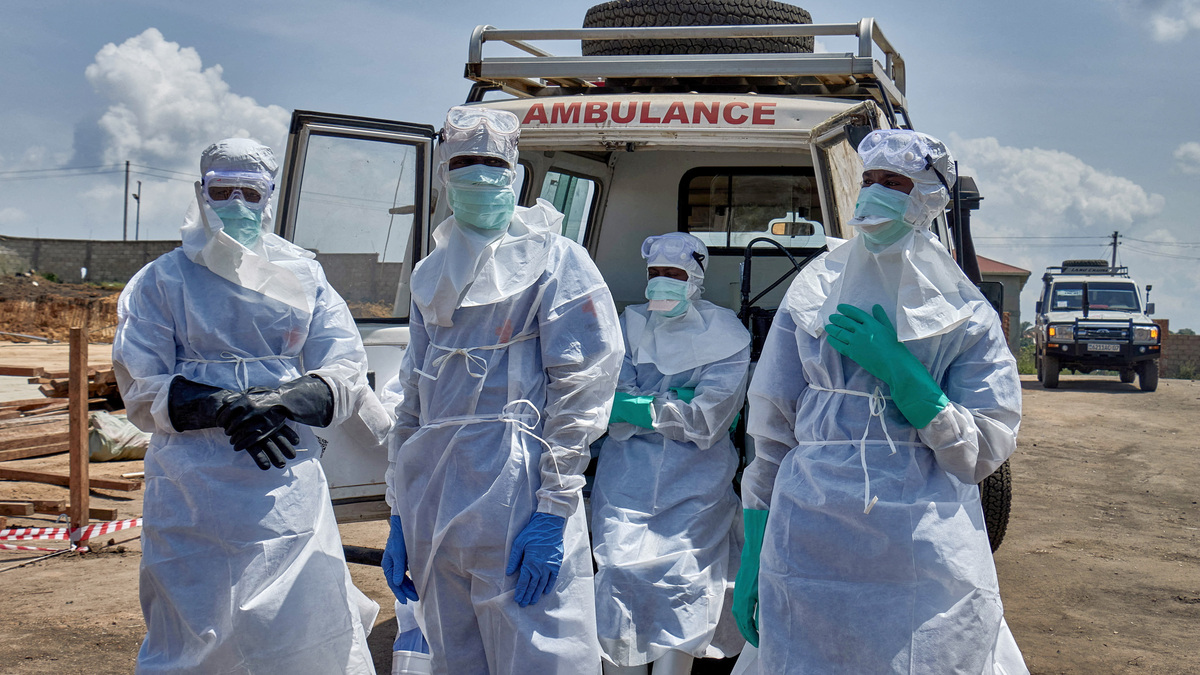 Red Cross workers wearing personal protective equipment (PPE) gather after handling the coffin of a man who died of Ebola virus, as aid agencies intensify efforts to contain the Ebola outbreak caused by the Bundibugyo virus, in Bunia, Ituri province, Democratic Republic of Congo, June 10, 2026. REUTERS/Gradel Muyisa Mumbere