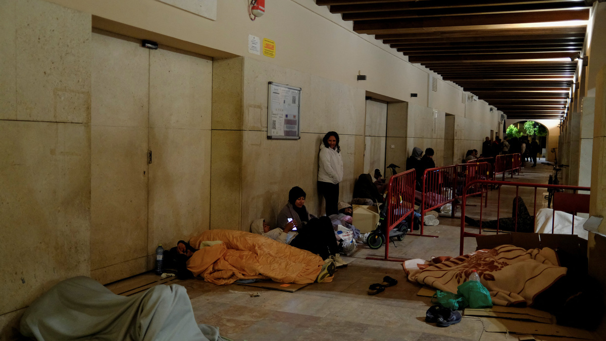 People rest as they wait in a queue in the early morning to obtain a vulnerability certificate to regularise their migration status, at the town hall of Almeria, Spain, April 21, 2026. REUTERS/Nacho Doce