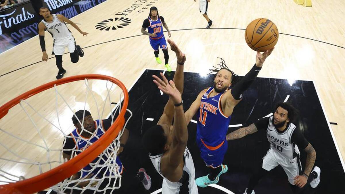  New York Knicks guard Jalen Brunson (11) drives to the basket past San Antonio Spurs forward Julian Champagnie (30) during game five of the 2026 NBA Finals at Frost Bank Center. | Geoff Burke-Pool Photo via Imagn Images 