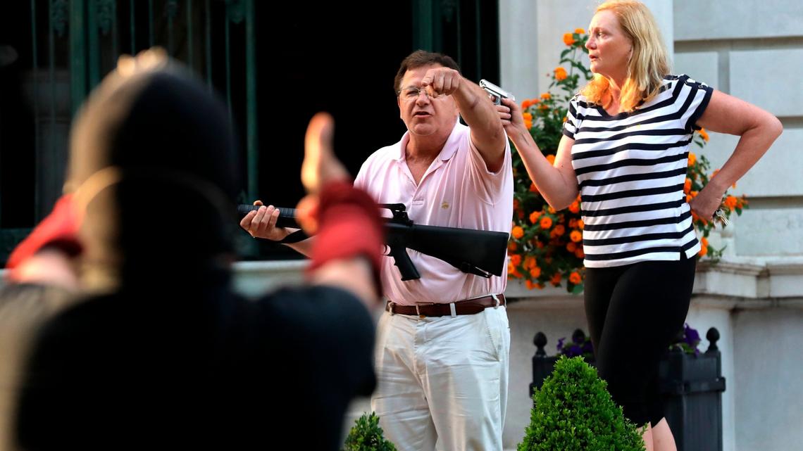 FILE - In this June 28, 2020 file photo, armed homeowners Mark and Patricia McCloskey, standing in front their house along Portland Place confront protesters marching to St. Louis Mayor Lyda Krewson’s house in the Central West End of St. Louis. Mark McCloskey, a St. Louis personal injury lawyer who gained national attention after he and his wife waved guns at racial injustice protesters who marched near their home last summer, is on the verge of a 2022 Senate run.(Laurie Skrivan/St. Louis Post-Dispatch via AP, File)