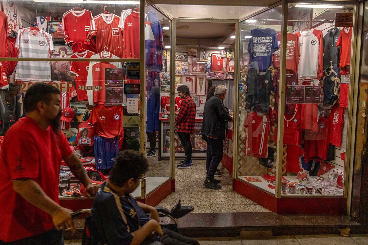 Fans pass by an Argentino Juniors fan store near the stadium in Buenos Aires, Argentina, April 18, 2026. A multimillion-dollar battle for a soccer god's brand is being waged across continents, burning investors and tearing his family apart. (Sarah Pabst/The New York Times)