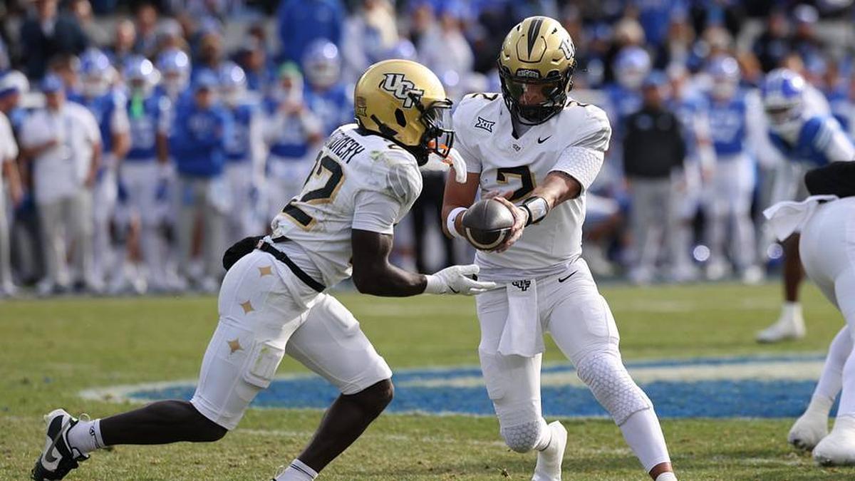  Nov 29, 2025; Provo, Utah, USA; UCF Knights quarterback Tayven Jackson (2) hands the ball off to running back Myles Montgomery (22) during the second quarter of the game against the BYU Cougars at LaVell Edwards Stadium. Mandatory Credit: Rob Gray-Imagn Images | Rob Gray-Imagn Images 