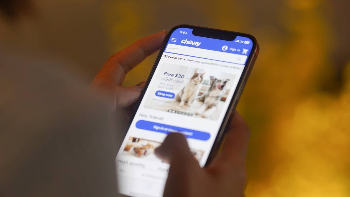 woman scrolling chewy on her phone.