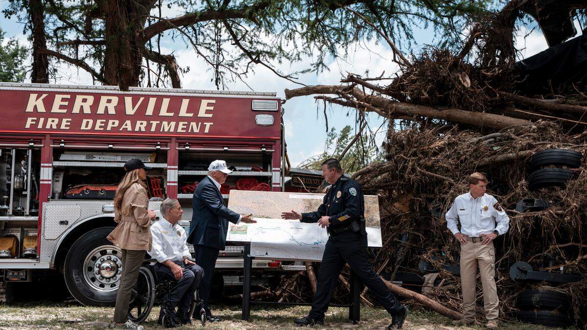 President Donald Trump and first lady Melania Trump, together with Gov. Greg Abbott, get a briefing on Friday in Kerrville, Texas, after deadly floods claimed at least 120 lives in the area.