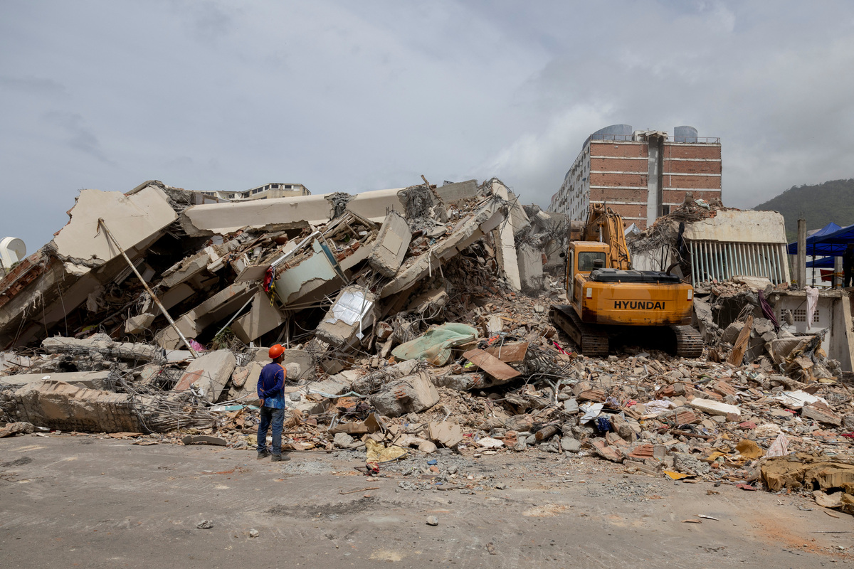 An excavator removes debris from the collapsed apartment building where survivor Maria Alejandra Sanz was trapped for 17 hours after twin earthquakes in La Guaira, Venezuela, July 5, 2026. REUTERS/Ricardo Arduengo