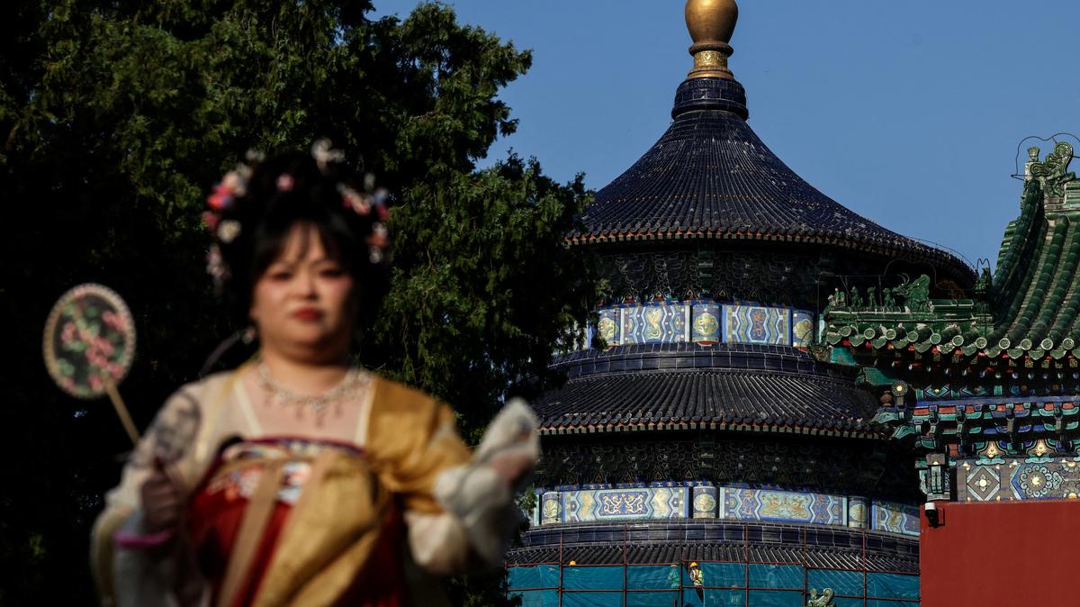 A woman dressed in traditional dress looks on next to the Hall of Prayer for Good Harvests at the Temple of Heaven, or Tiantan Park, ahead of this week’s U.S. President Donald Trump's visit to China, in Beijing, China, May 11, 2026. REUTERS/Maxim Shemetov