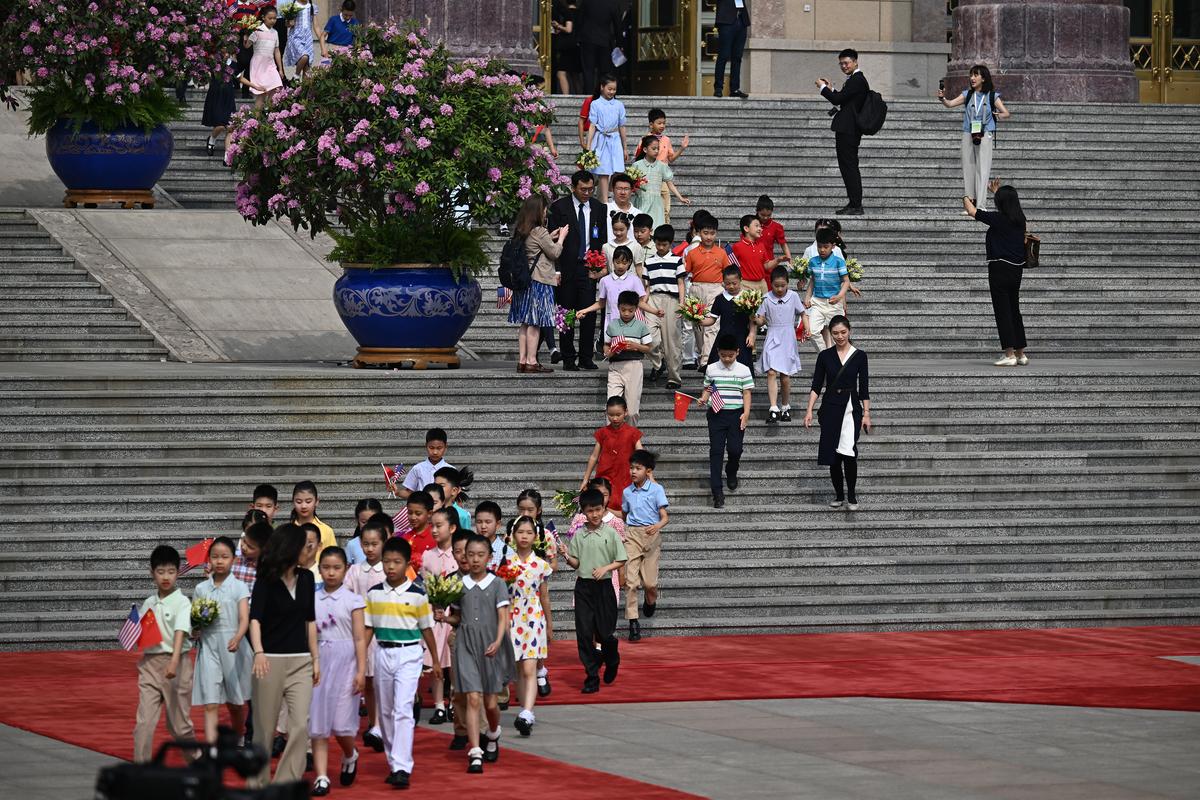 Children carry American and Chinese flags at the Great Hall of the People in Beijing on Thursday, May 14, 2026, during President Donald Trump's visit to China for a two-day summit with China's leader, Xi Jinping. (Kenny Holston/The New York Times)