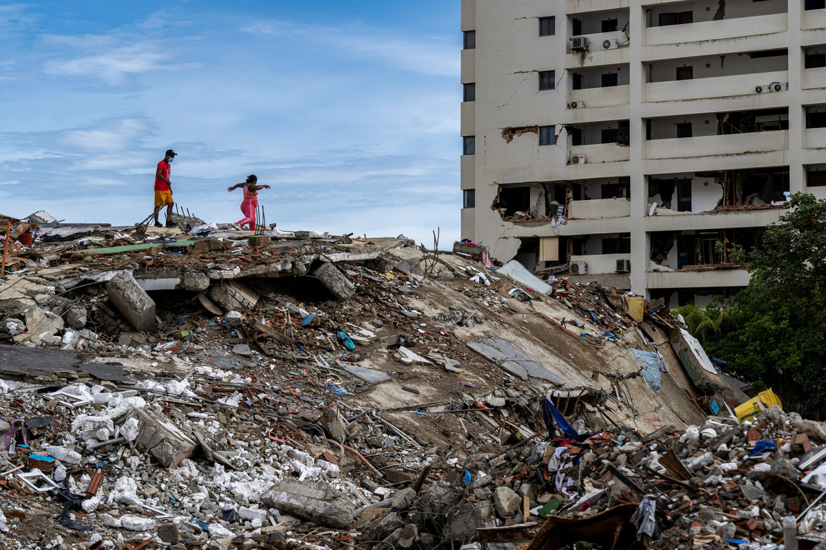 Locals walk on the top of the rubble of a collapsed building in Caraballeda, La Guaira state, Venezuela, on June 30, 2026, following the June 24 twin earthquakes. MIGUEL MEDINA/Pool via REUTERS