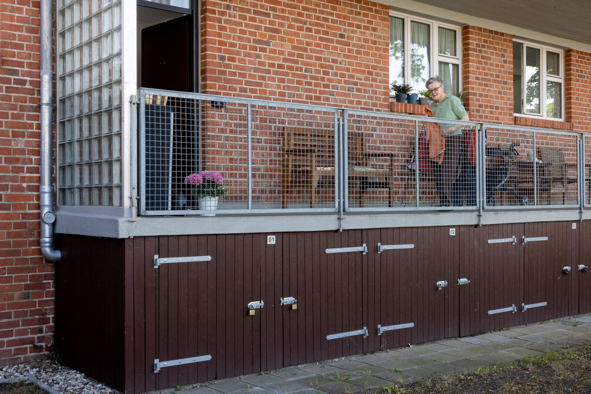 A resident in her 90s, who moved into the building in 1956, stands on the balcony of her apartment in one of the Houses with Balcony Access (Laubenganghauser), designed by second Bauhaus director Hannes Meyer and constructed between 1929 and 1930 in the Dessau-Torten estate, a UNESCO World Heritage Site since 2017, in Dessau, Germany, June 17, 2026. REUTERS/Axel Schmidt