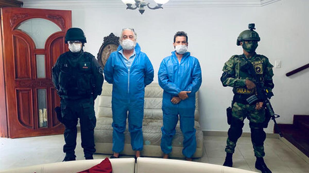 En esta fotografía proporcionada por la fiscalía de Colombia, un agente de la policía y un soldado flanquean a Mark Grenon (segundo desde la izquierda) y a su hijo Joseph Grenon, durante un registro en Santa Marta, Colombia.