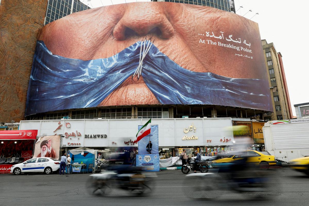 FILE PHOTO: People drive past an anti-U.S. billboard depicting U.S. President Donald Trump and the Strait of Hormuz, in Tehran, Iran, May 17, 2026. Majid Asgaripour/WANA (West Asia News Agency) via REUTERS