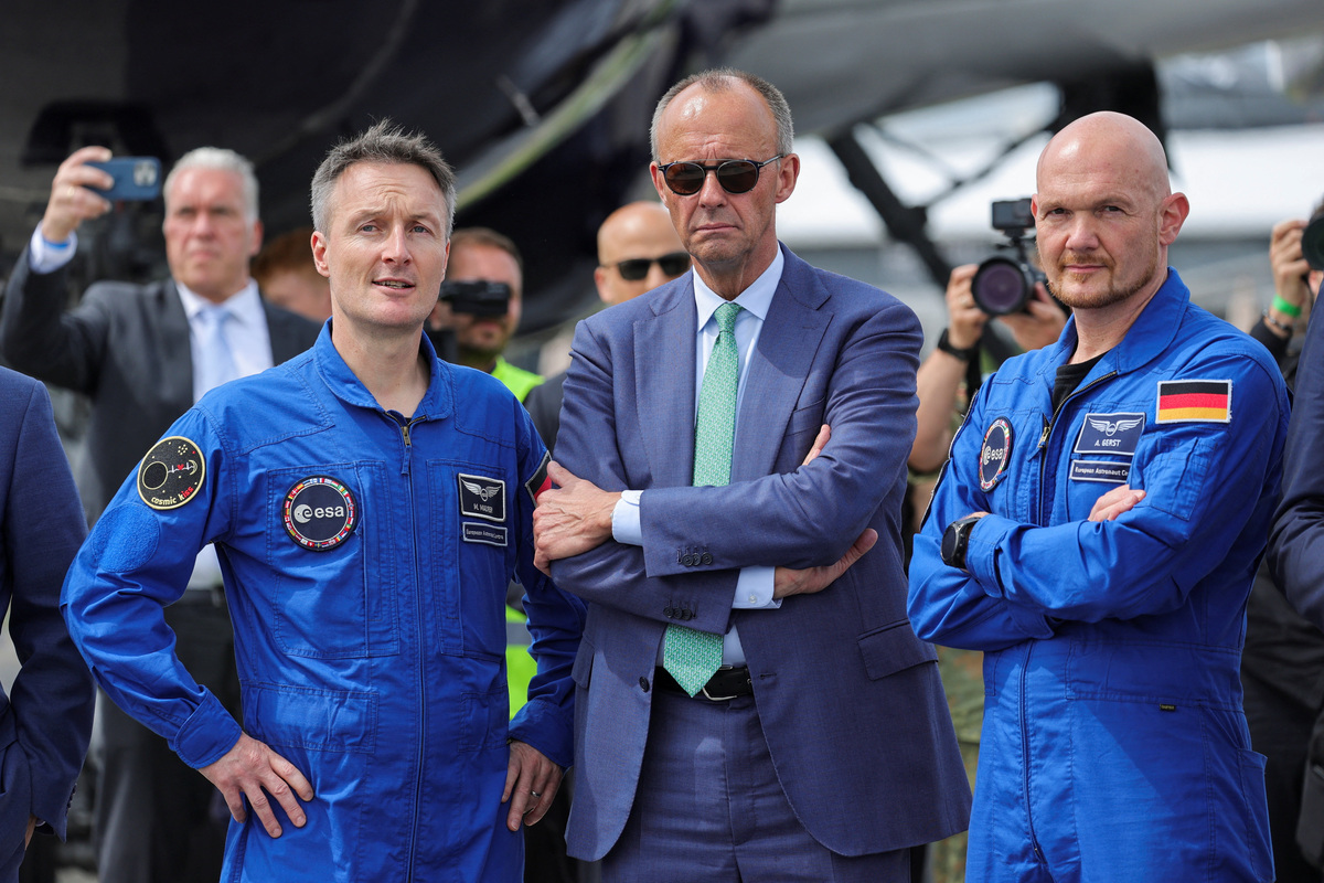 German Chancellor Friedrich Merz poses with European Space Agency (ESA) German astrounauts Alexander Gerster and Matthias Maurer during the International Aerospace Exhibition ILA on the opening day at Schoenefeld Airport in Berlin, Germany, June 10, 2026. REUTERS/Fabrizio Bensch