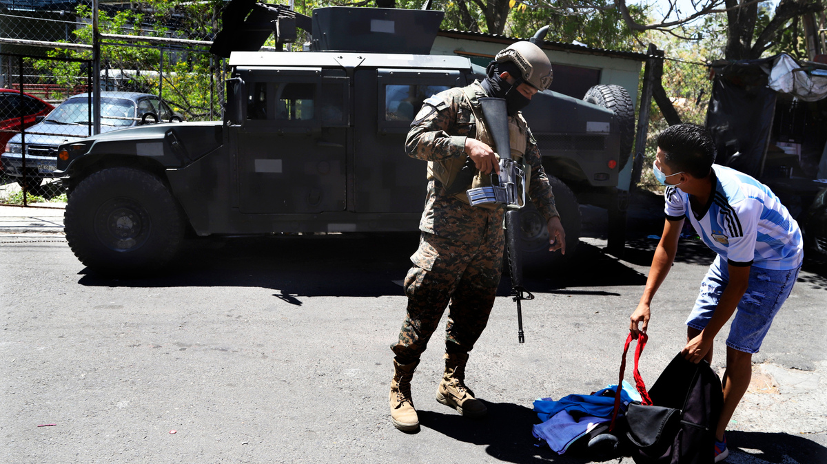 Un soldado revisa la mochila de un hombre a la salida de la Comunidad Las Palmas, un barrio que se supone que está bajo el control de la pandilla Barrio 18 en San Salvador, El Salvador, el domingo 27 de marzo de 2022. El Congreso de El Salvador accedió al pedido del presidente Nayib Bukele de declarar el estado de emergencia, en medio de una ola de asesinatos relacionados con pandillas durante el fin de semana. (AP Foto/Salvador Meléndez)